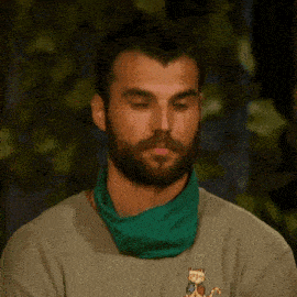 a man with a beard wearing a green bandana around his neck