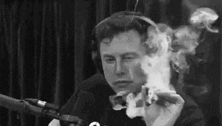 elon musk is smoking a cigarette in a black and white photo .