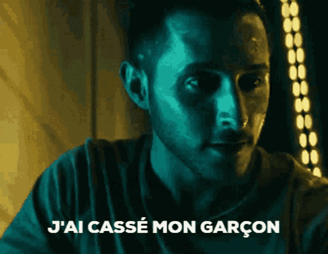 a man in a dark room with the words " j'ai casse mon garcon " below him