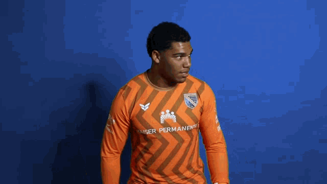 a man wearing an orange shirt that says ser permanent on it