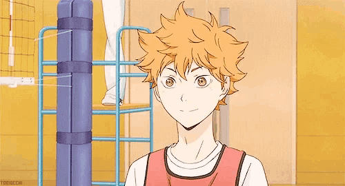 a boy with orange hair is standing next to a volleyball net in a gym .