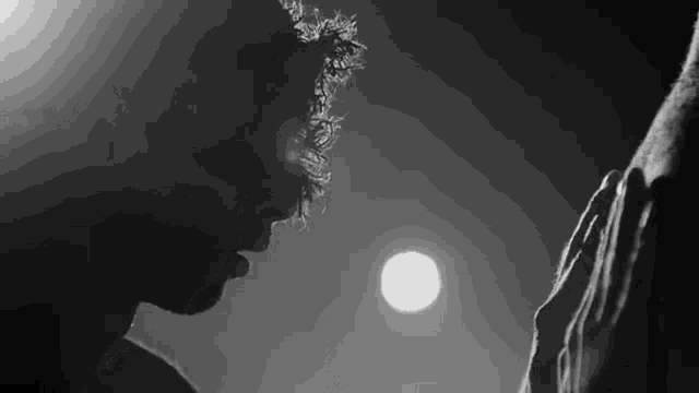 a black and white photo of a man with a crown of thorns on his head standing next to a woman .