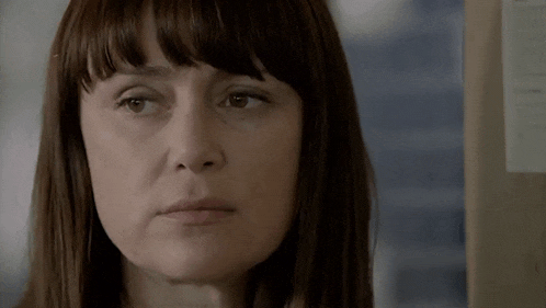 a close up of a woman 's face with a box in the background that says priority mail