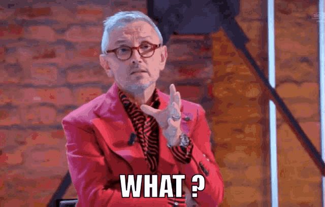 a man wearing glasses and a red jacket says what
