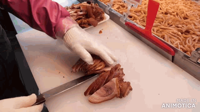 a person is cutting meat on a cutting board with the words made in animotica visible