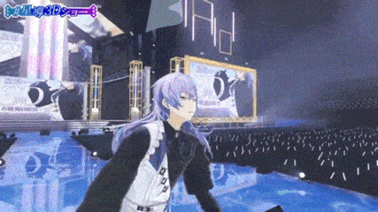 a man with long purple hair is standing on a stage in front of a large screen .