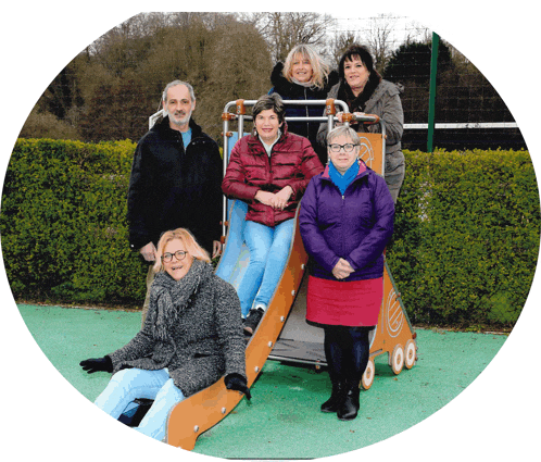 a group of people are posing for a picture on a slide at a playground