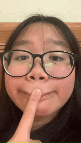 a woman wearing glasses is making a funny face