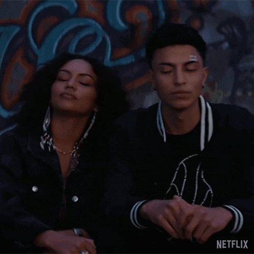 a man and a woman are sitting next to each other with their eyes closed .