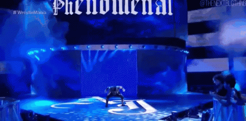 a man is standing on a stage in front of a blue background with the word phenomenal on it .