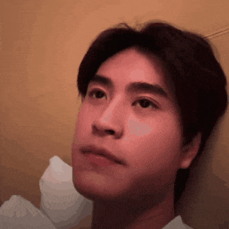 a close up of a young man 's face with a serious look on his face .