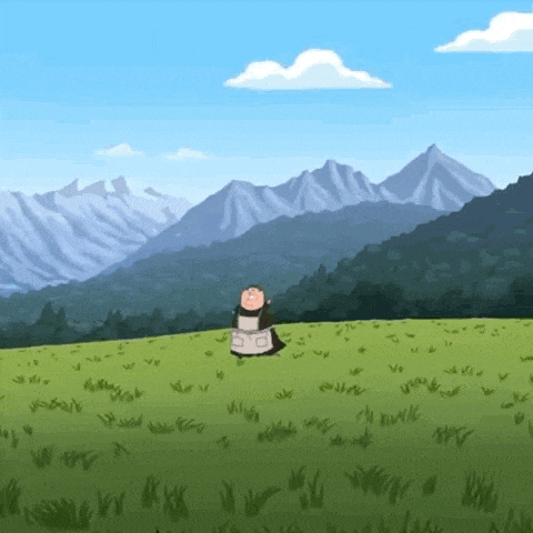 a cow is standing in a grassy field with mountains in the background .