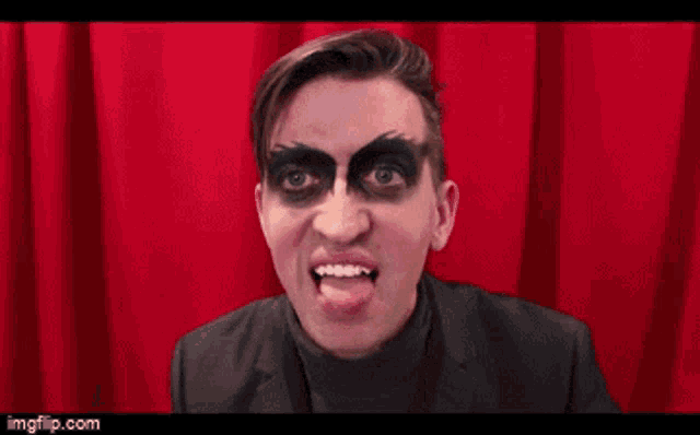 a man with black makeup on his face and the word quit on his face