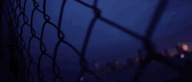 a blurry picture of a chain link fence with a red white and blue glitch effect on it