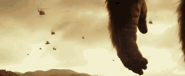 a group of helicopters are flying in the sky above a giant foot