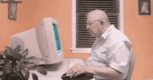 an older man is sitting at a desk in front of a computer .