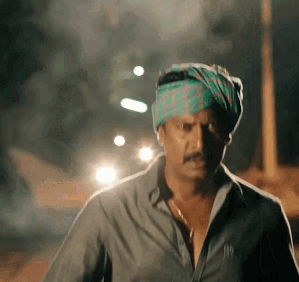 a man wearing a turban and a shirt is walking down a street .