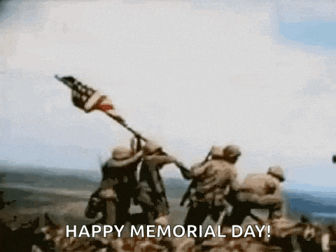 a group of soldiers are raising an american flag on top of a mountain .