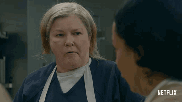 a woman in an apron is talking to another woman with a netflix logo in the corner