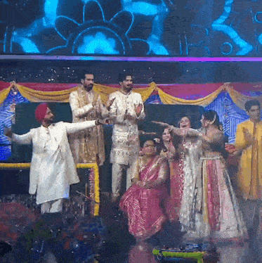 a group of people standing on a stage with their hands up