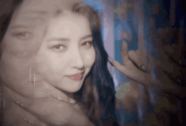 a close up of a woman 's face with a blurry background behind her