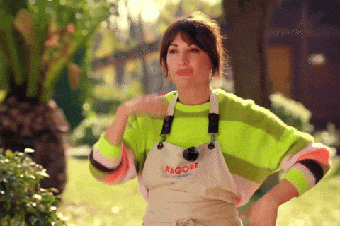 a woman wearing a neon green sweater and an apron that says nagore on it
