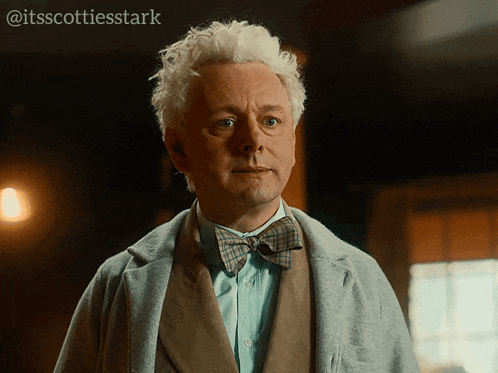 a man with white hair wearing a bow tie and a coat