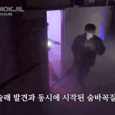a blurry picture of a person standing in front of a door that says okjil treasure