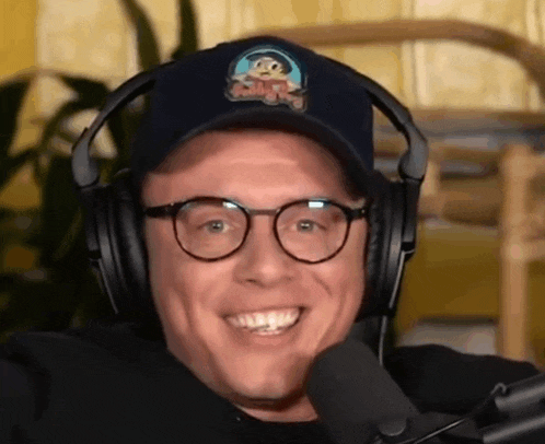 a man wearing headphones and a hat with a monkey on it