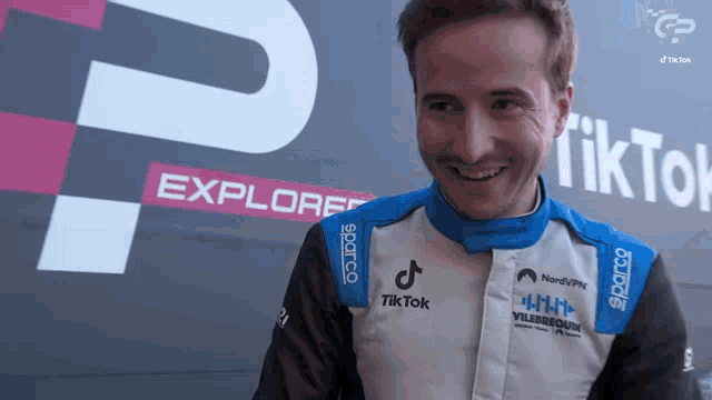 a man wearing a white and blue jacket with tiktok on it