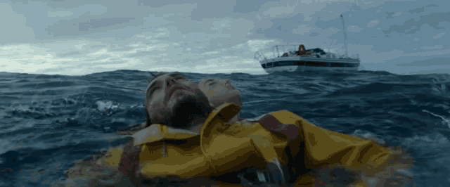 a man in a yellow jacket is being rescued from the water