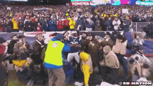 a football player with the number 25 on his jersey is surrounded by people