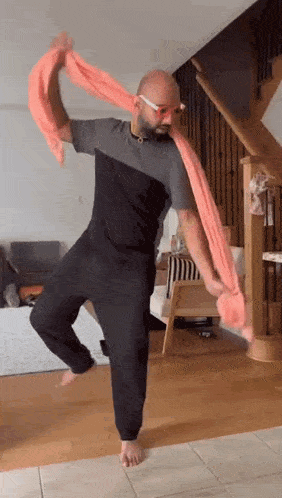 a man is dancing with a scarf around his neck .