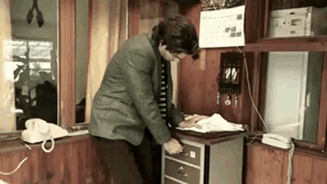a man in a suit and tie is standing in front of a desk