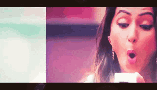 a woman with her mouth open is looking at her phone