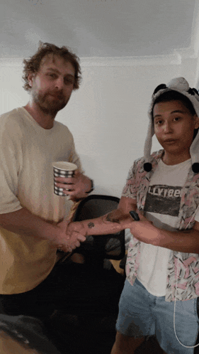 a man shaking hands with a woman who is wearing a shirt that says llytribe
