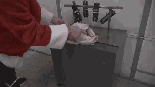 a man in a santa suit is holding a turkey