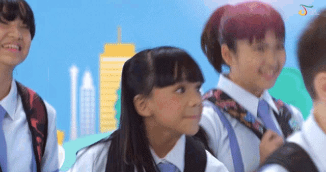 a group of children with backpacks are smiling in front of a cityscape