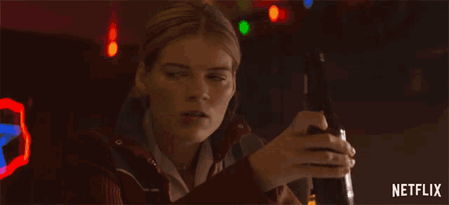 a woman holding a bottle of beer with a netflix logo in the corner