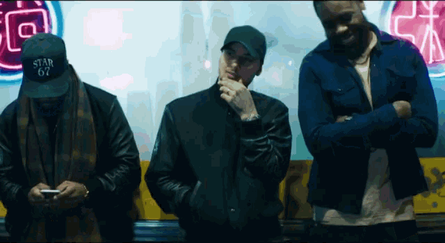 a man wearing a hat that says star 67 stands next to two other men