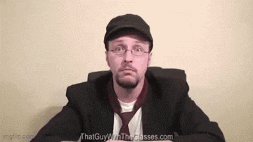a man wearing glasses and a hat is sitting at a table with the website thatguywiththeglasses.com in the background