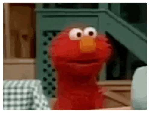 elmo from sesame street is standing in front of a table with a checkered tablecloth .