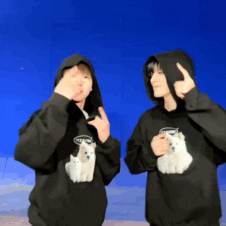 two people wearing black hoodies with a dog on the front