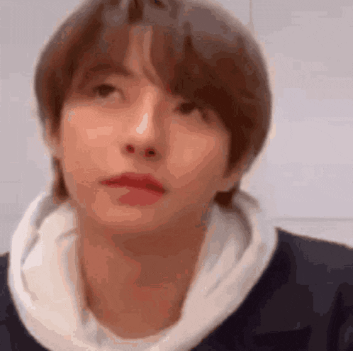 a close up of a young man 's face with a hoodie on .
