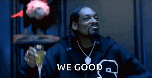 snoop dogg is wearing a fur coat and giving a thumbs up sign while sitting in a chair .