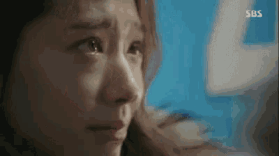 a close up of a woman 's face with tears coming down her face .