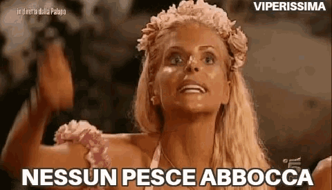 a woman with a flower crown on her head is making a funny face and says nessun pesce abbocca .