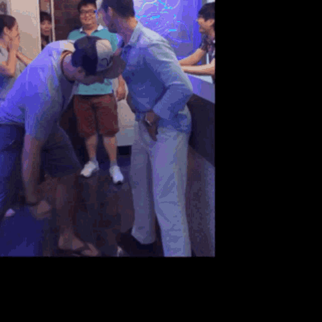 a man in a blue shirt and white pants is kneeling down