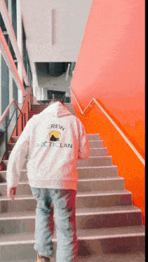 a person wearing a white sweatshirt that says crew on the back