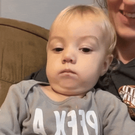 a baby wearing a shirt that says a x319 looks at the camera